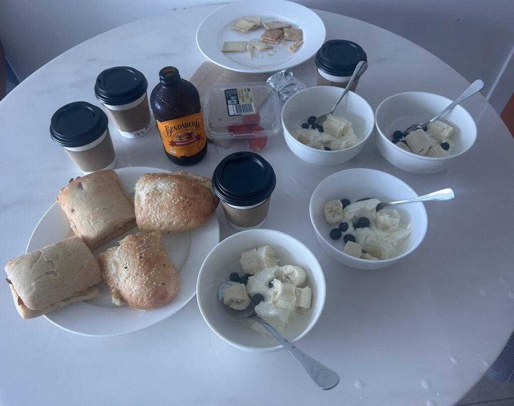 宿のテーブルに並んだ朝ごはん。パニーニとコーヒー、ヨーグルトとバナナとブルーベリー